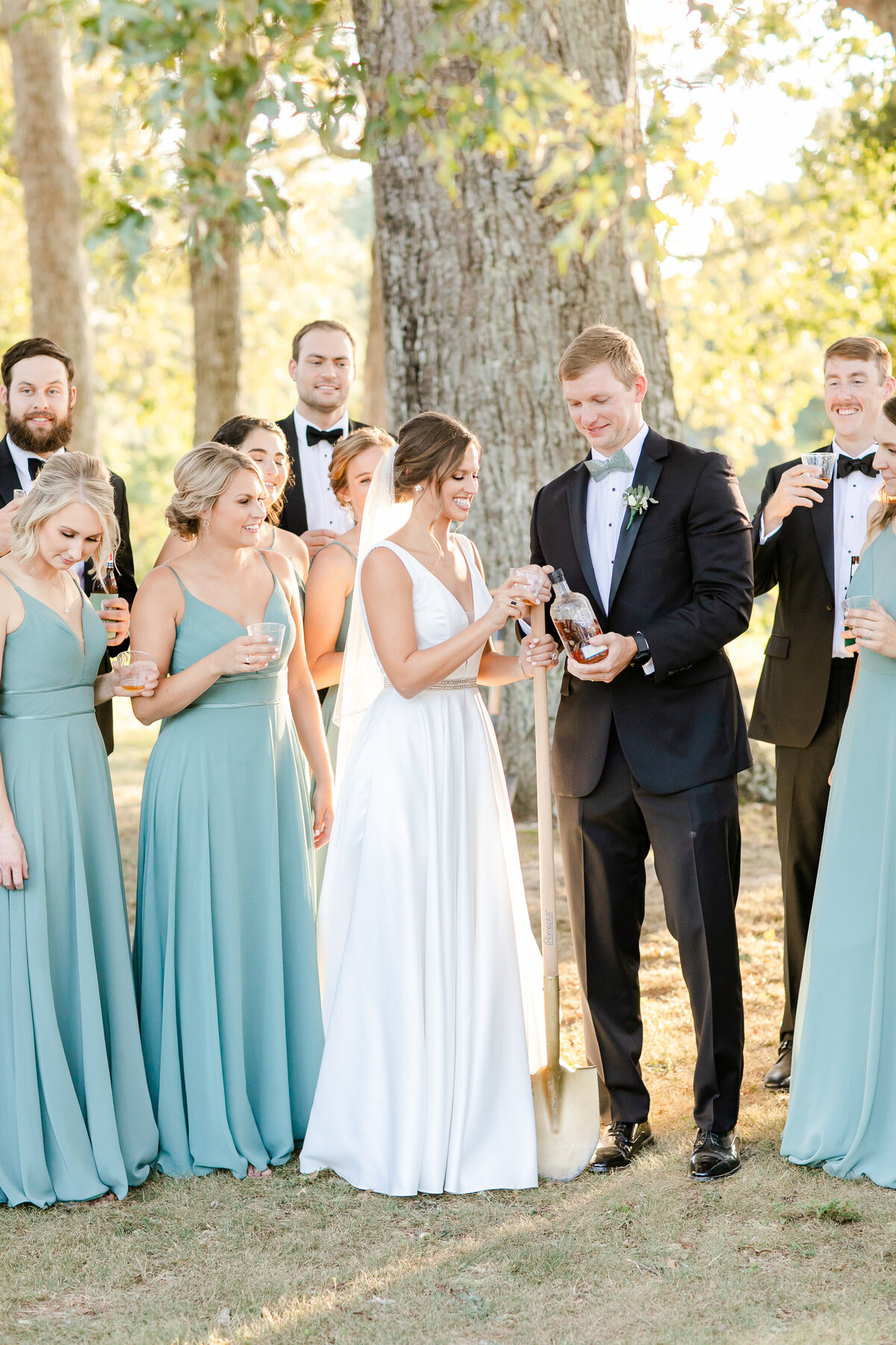 Bride and groom share bourbon after digging it up.