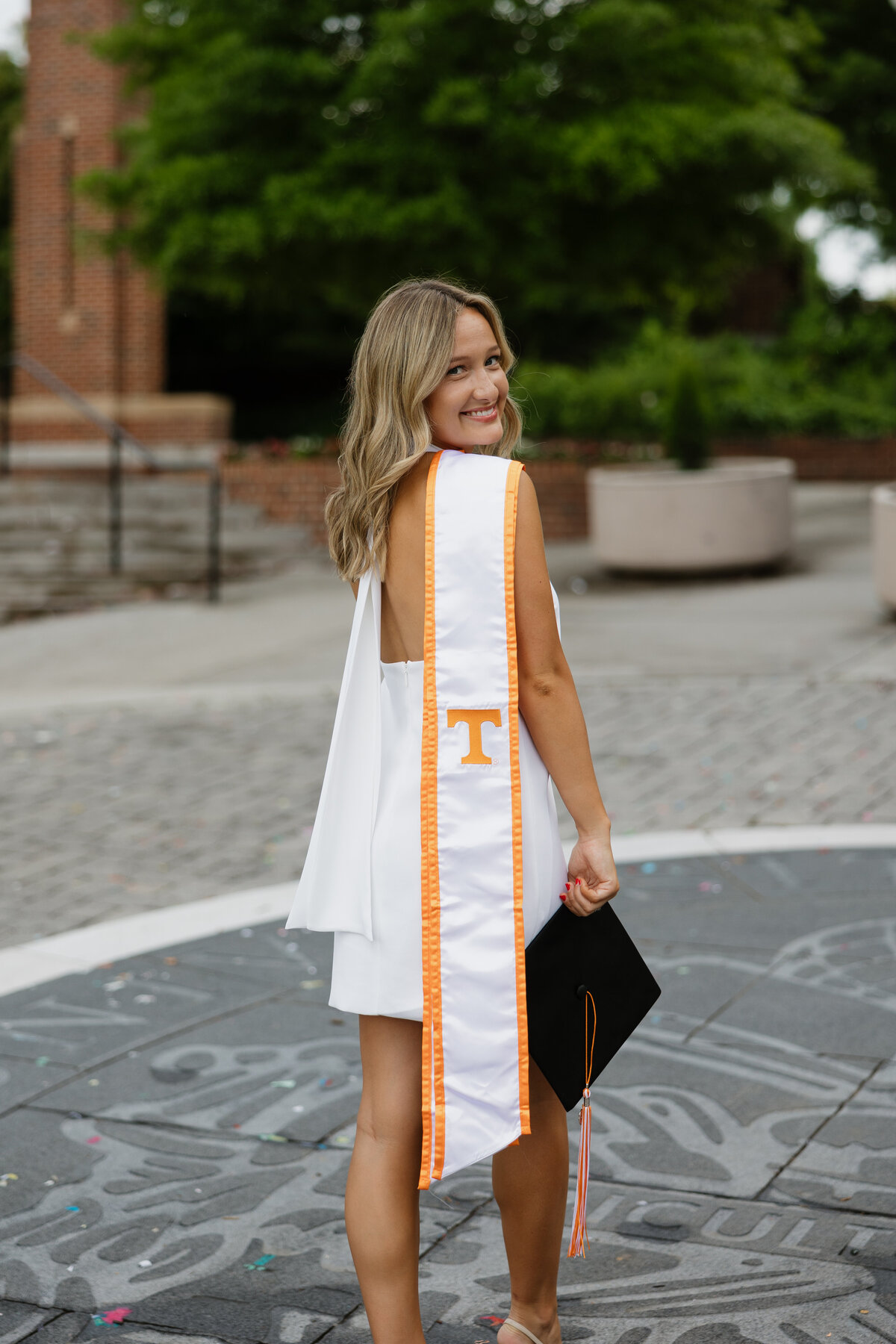 Cambell drapes her graduation stole over her shoulder as she looks at the camera.