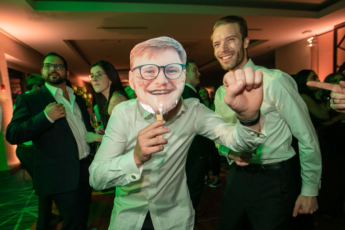 A man wearing glasses is holding a cardboard cutout of himself.