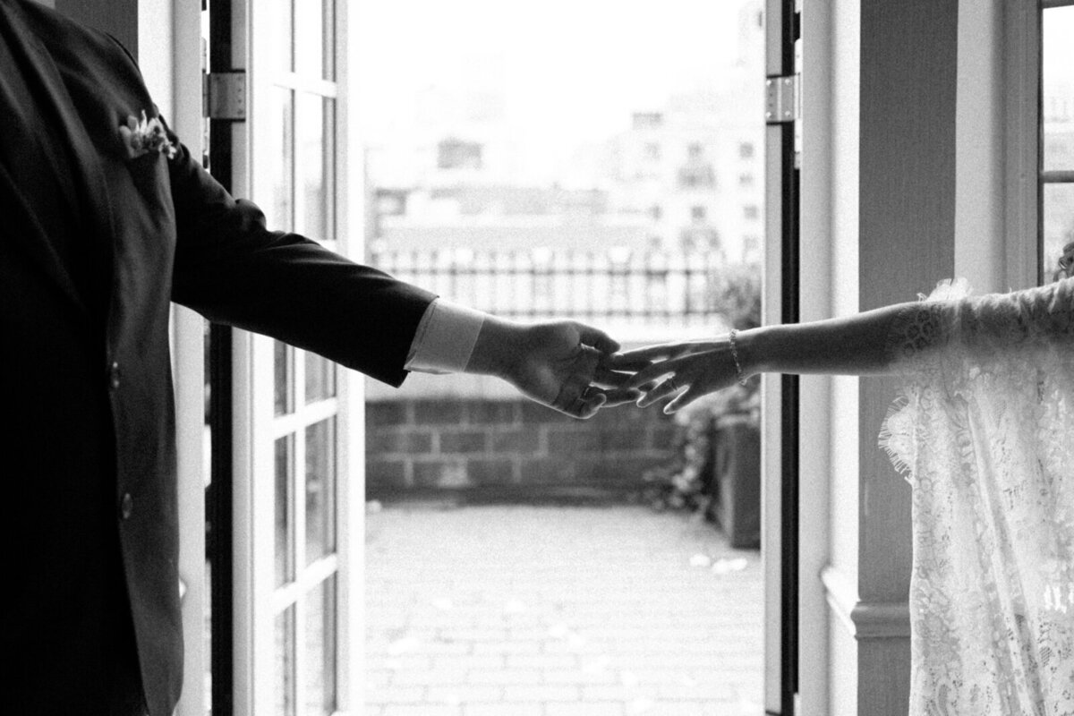 Bride and groom holding hands in front of New York City Skyline by chicago wedding photographer Allison Francois