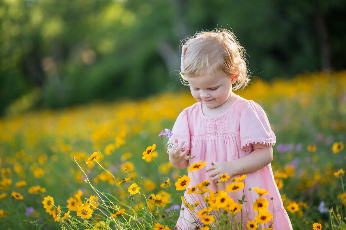 Red haired little girl playing in a field of wild yellow flowers located in Ocala, FL 