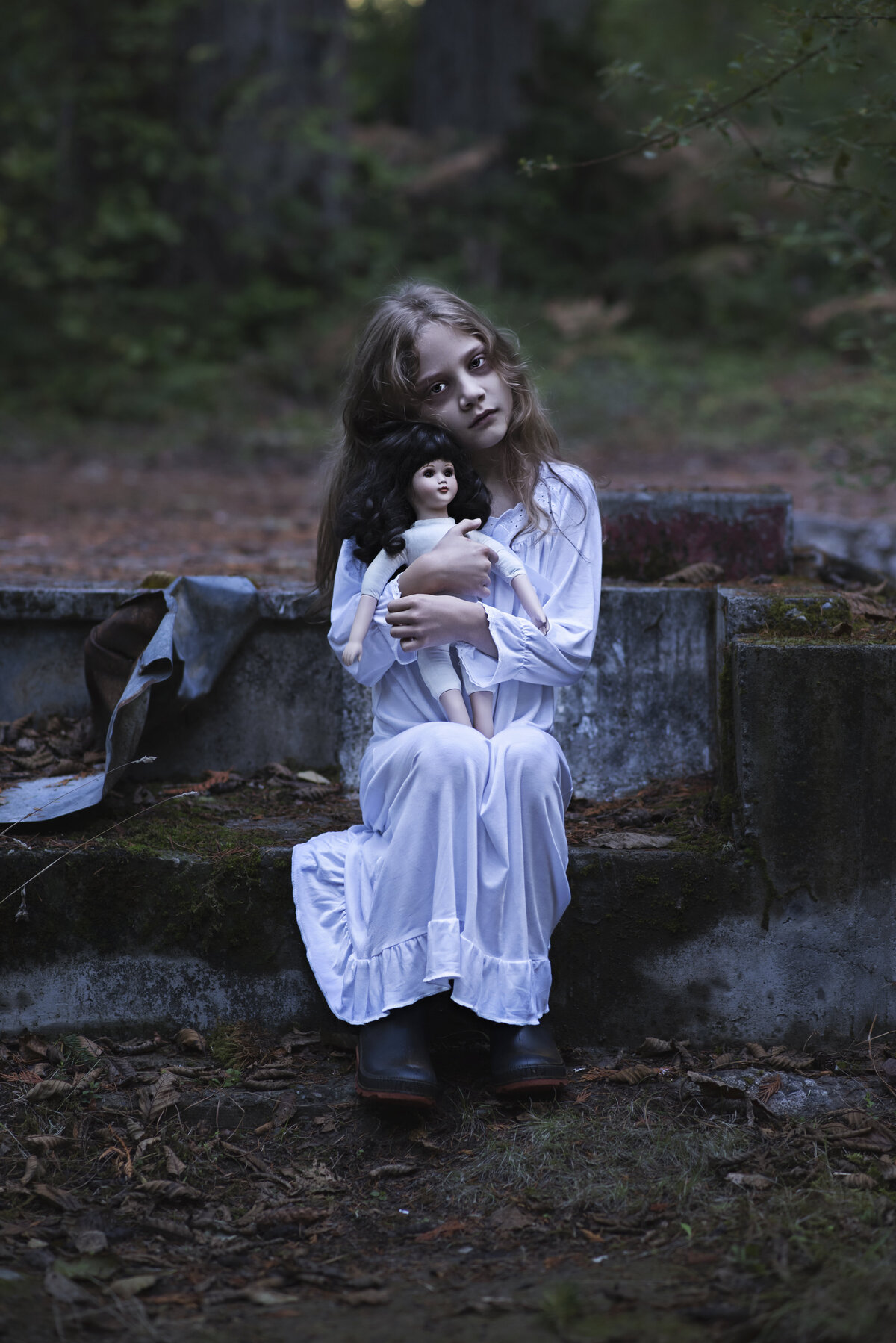 Little ghost girl sitting with her doll