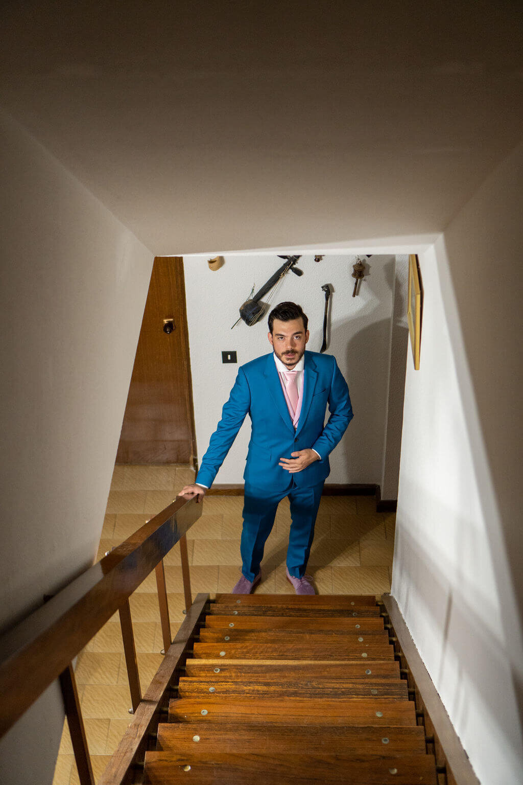 Best man looking up stairs to camera. Wearing blue suit