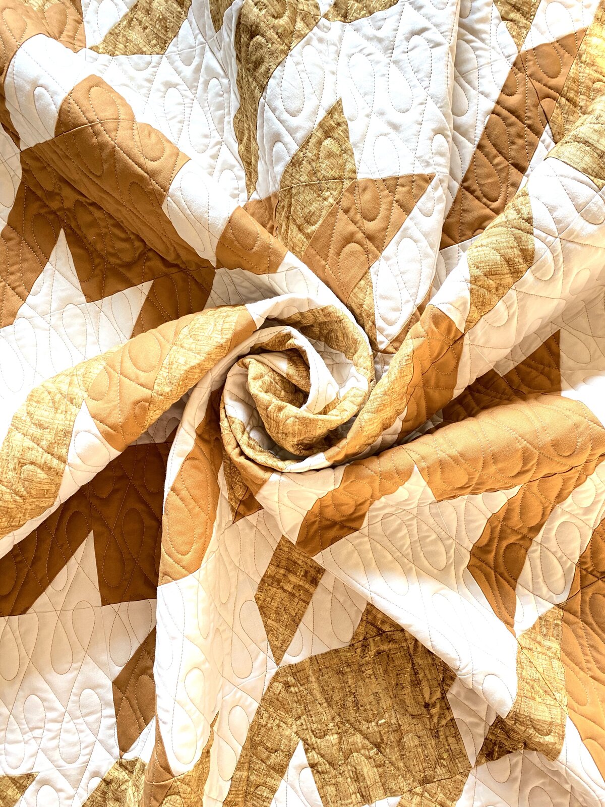 gold and white quilt features the crazy 8s quilting design