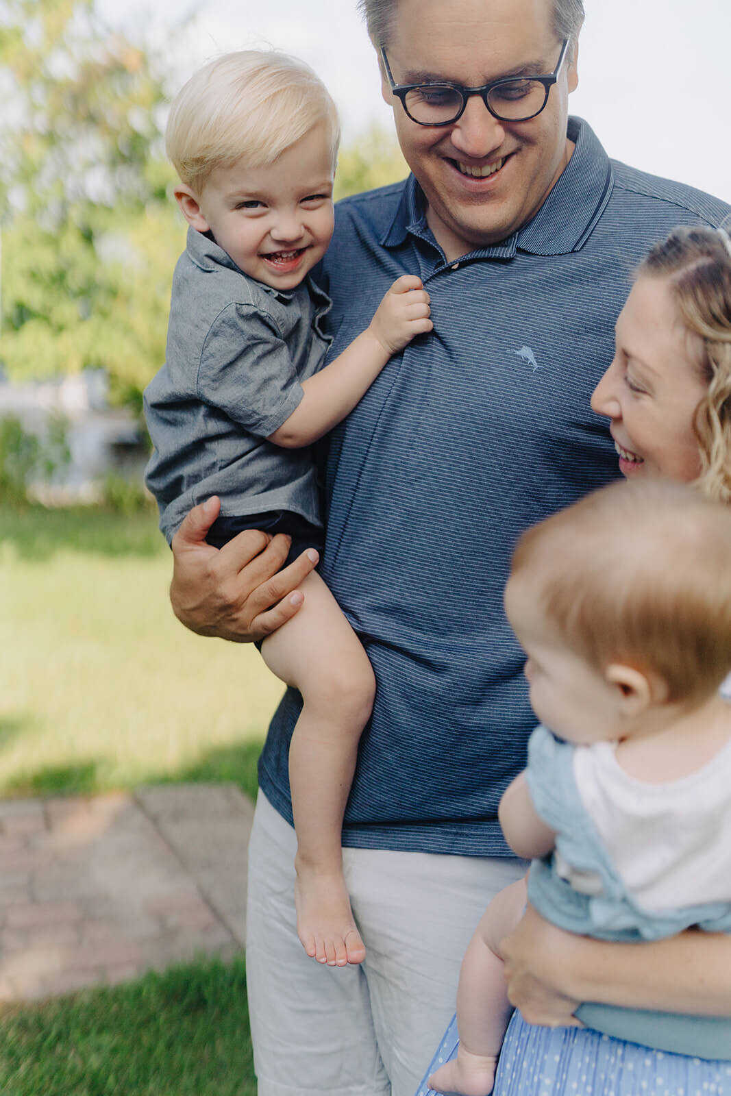 Parents holding two young kids for a generational photoshoot in Finger Lakes, NY