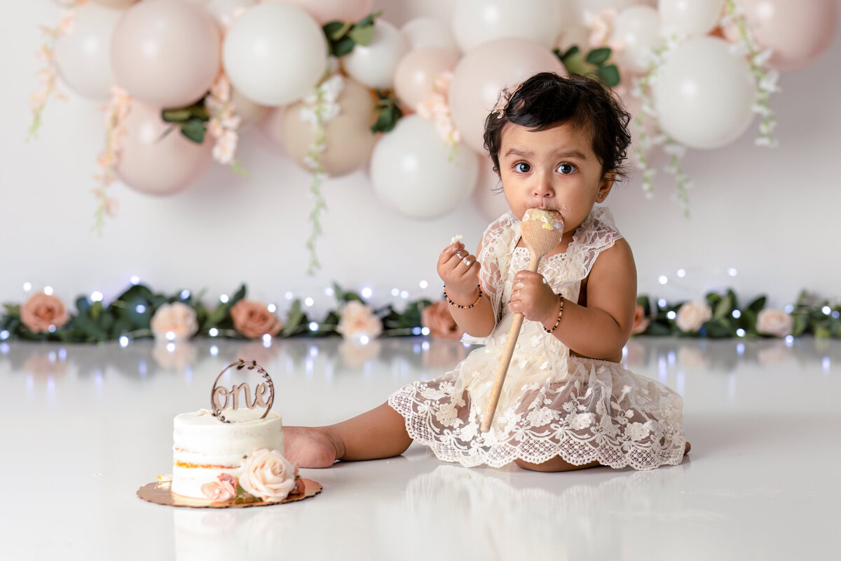 One year old Tampa baby enjoying a personalized luxury cake smash session with elegant decorations