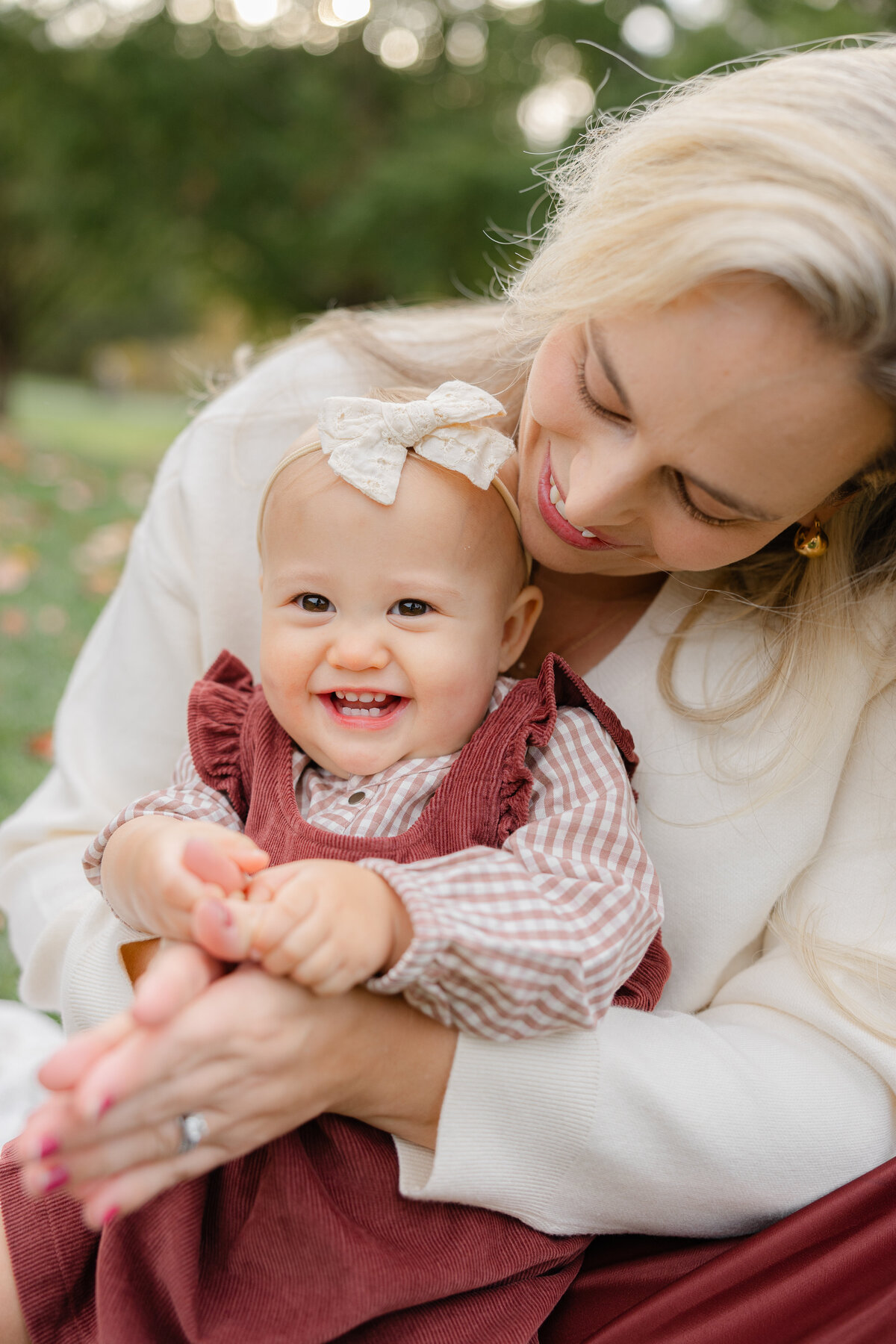 Worcester family photographer capturing a joyful moment between a mother and her smiling baby girl during an outdoor fall session
