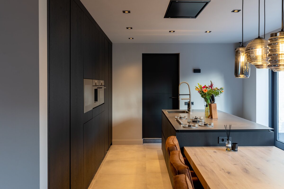 Moderne donkere keuken met houten eettafel