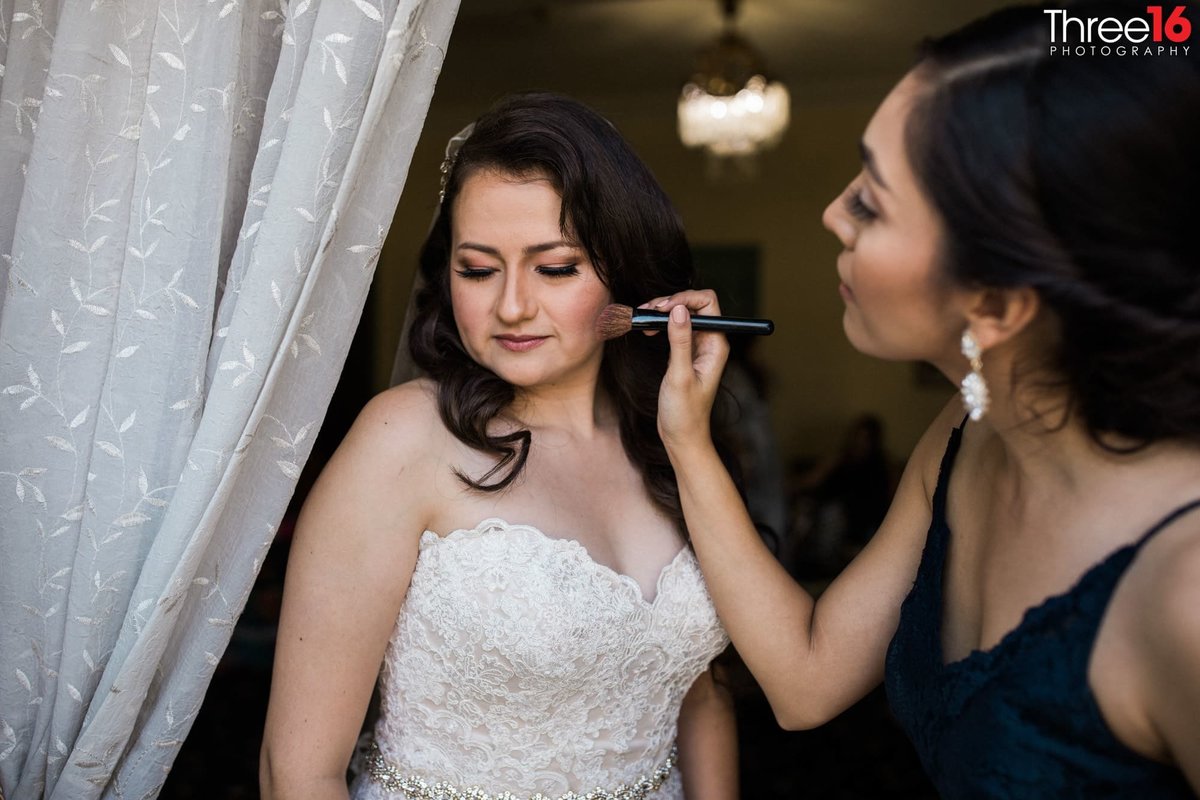 Bride receives final makeup touchup before the cermony
