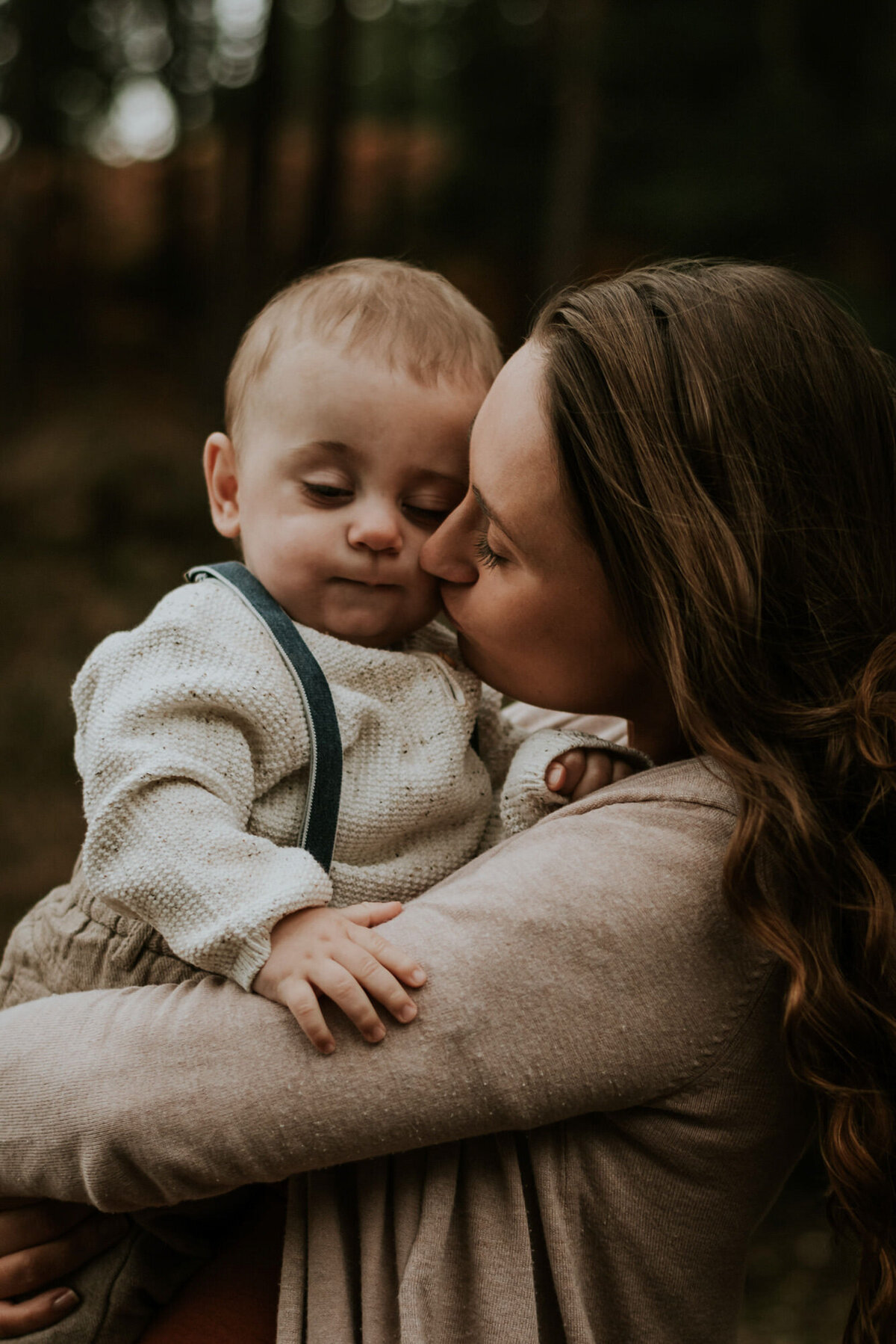 Mother kissing baby in portrait photo