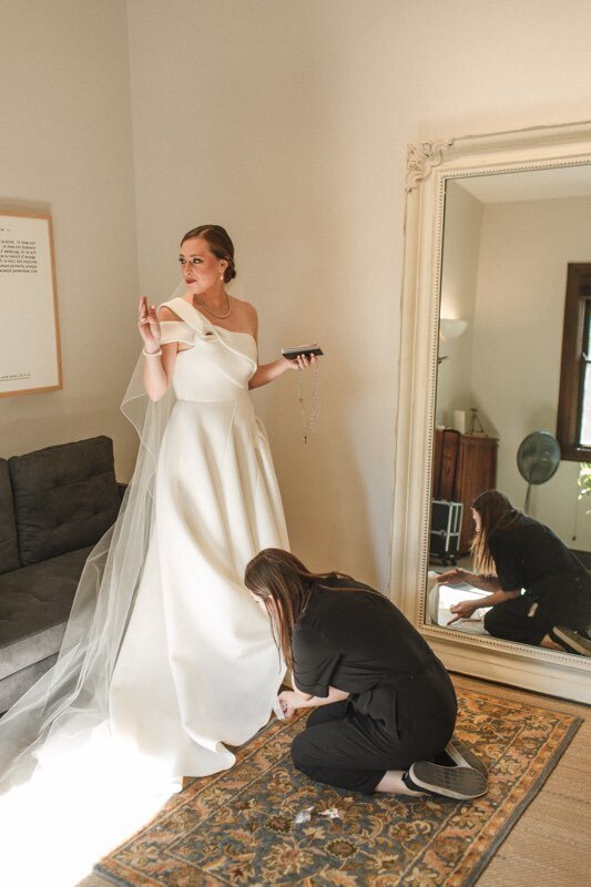 Becky Wegner assisting bride in gown