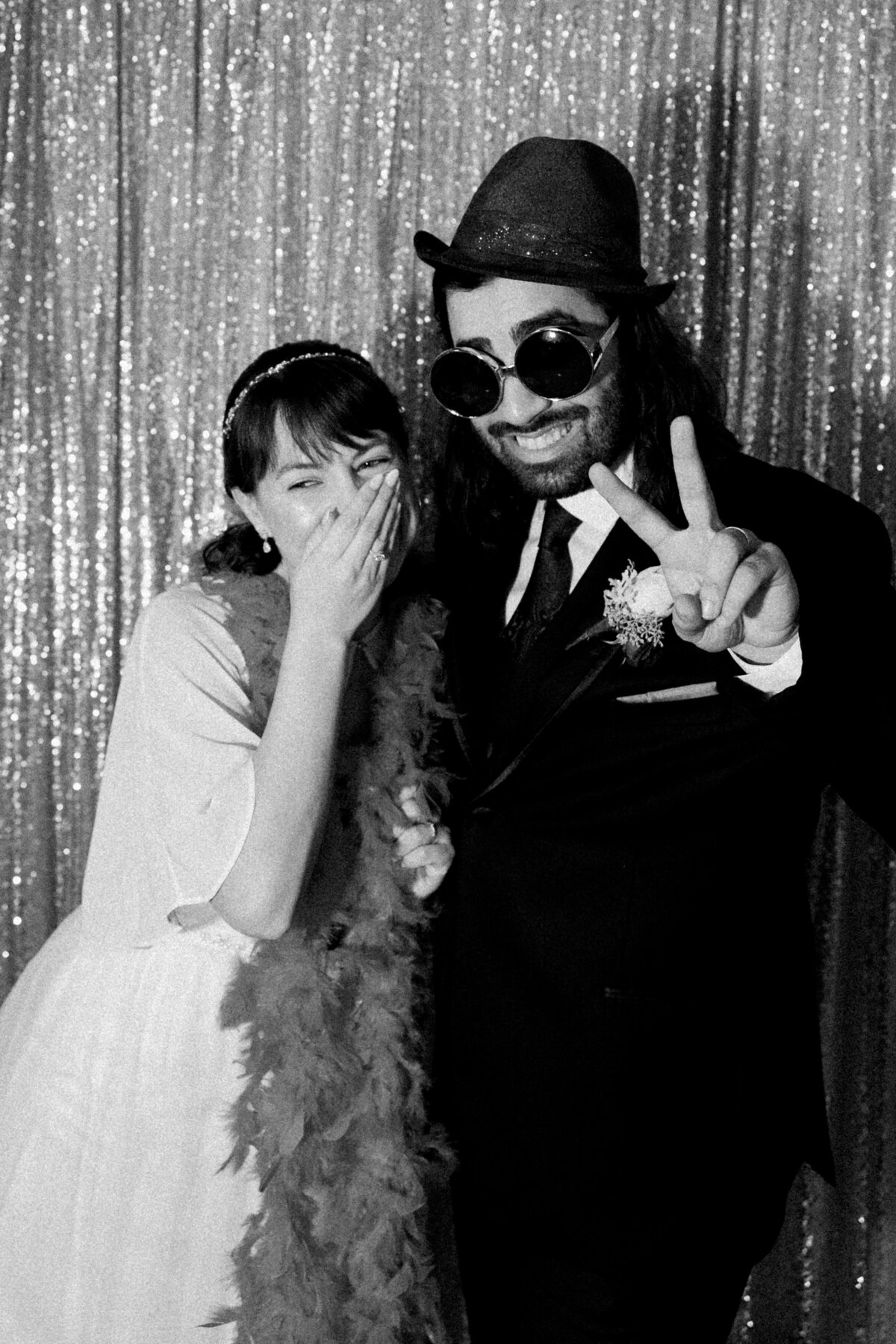 The bride and grooms having fun taking photos at the photobooth area of their reception