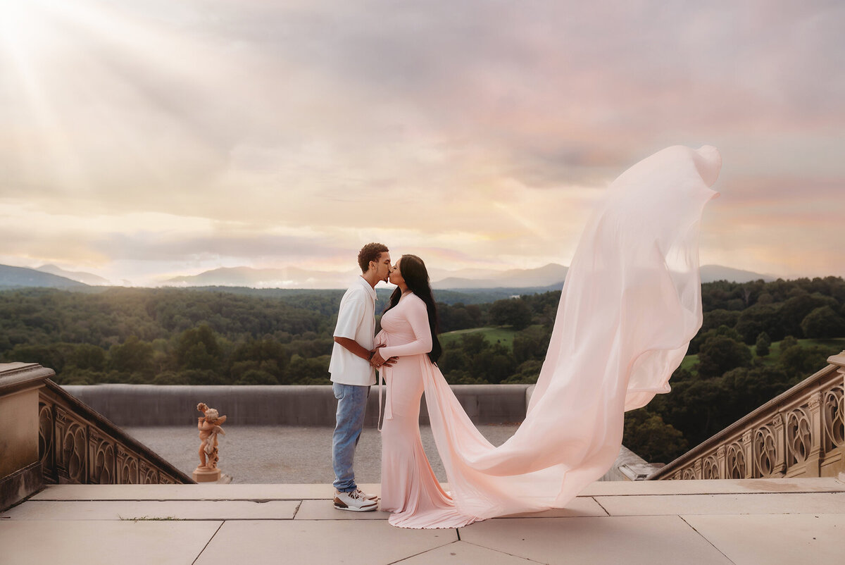 Expectant parents kiss during Maternity Photoshoot at Biltmore Estate in Asheville, NC.