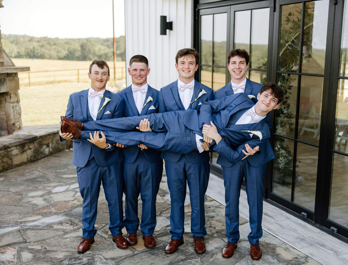 Groom and groomsmen in navy tuxedos from Emily Rae's in Longview Texas 