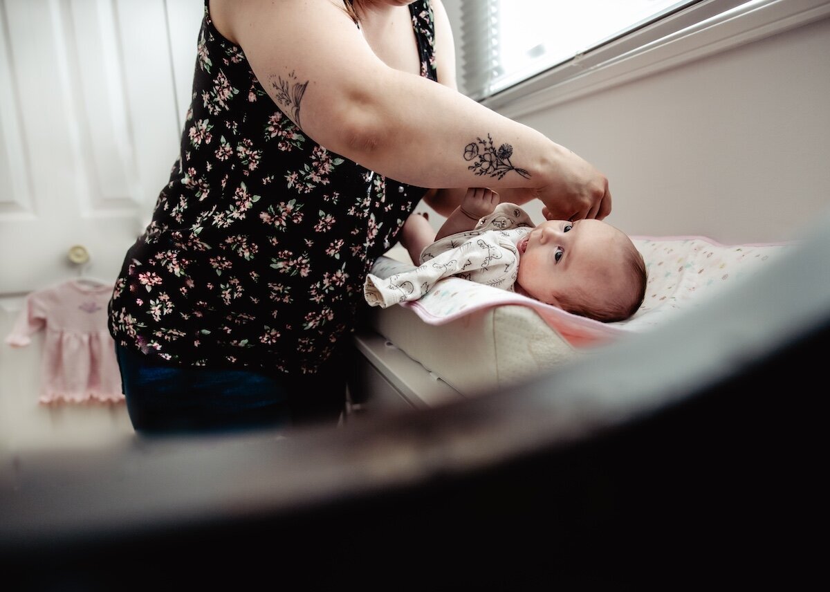 A mom changes her newborn baby's diaper