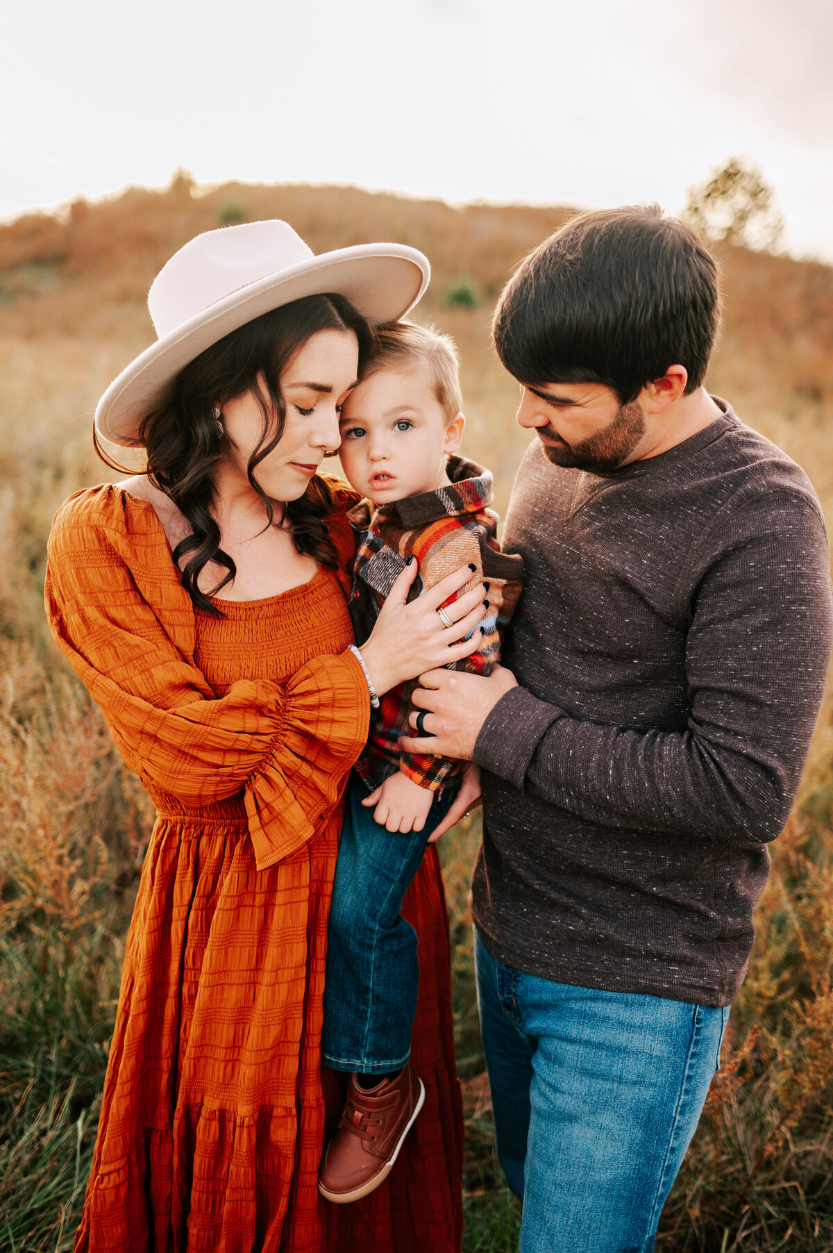 Branson MO family photographer Jessica Kennedy of The XO Photography captures family hugging on a hillside in the fall