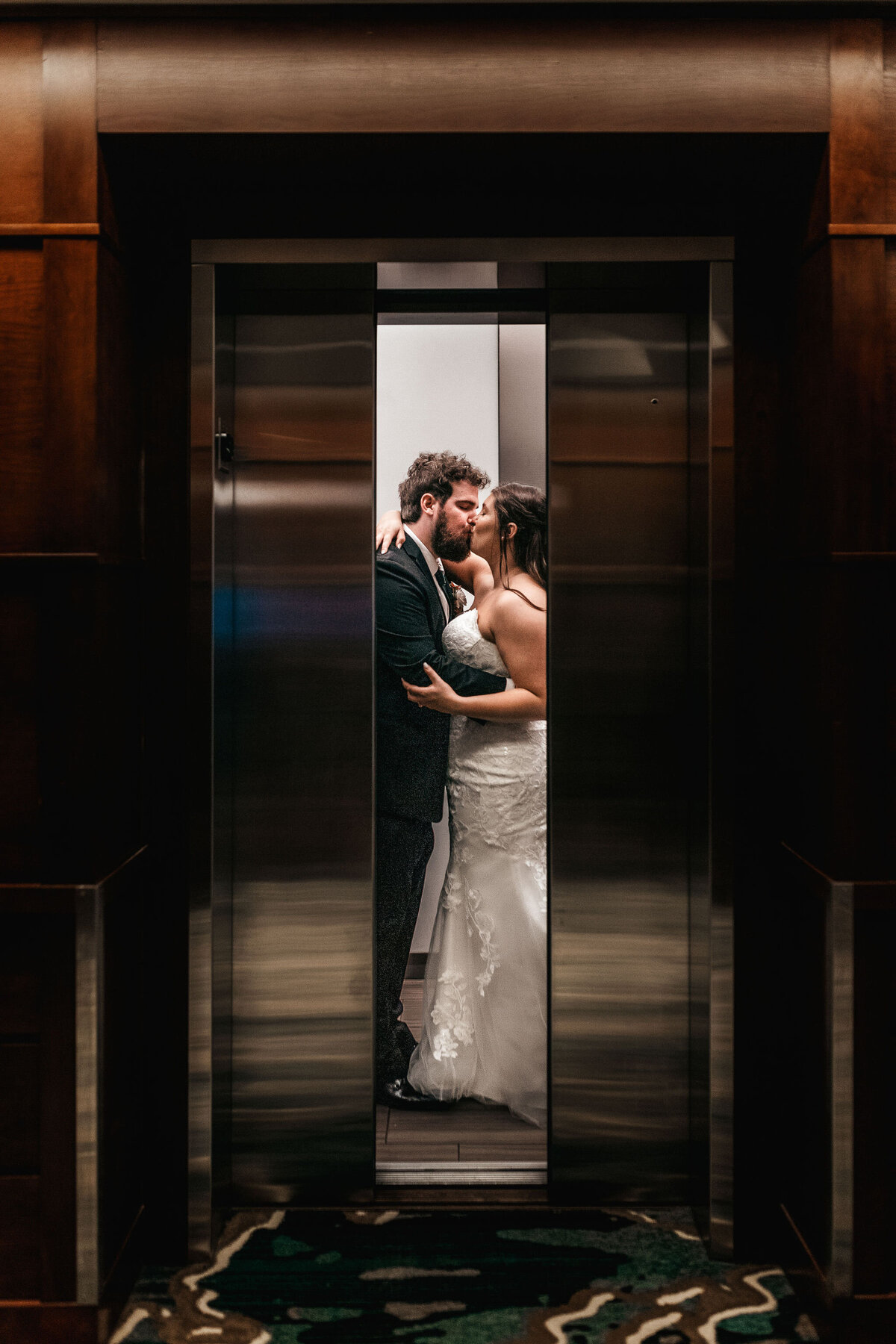 bride and groom sharing an intimate moment in the elevator at DoubleTree by Hilton in Manchester NH By Lisa Smith Photography