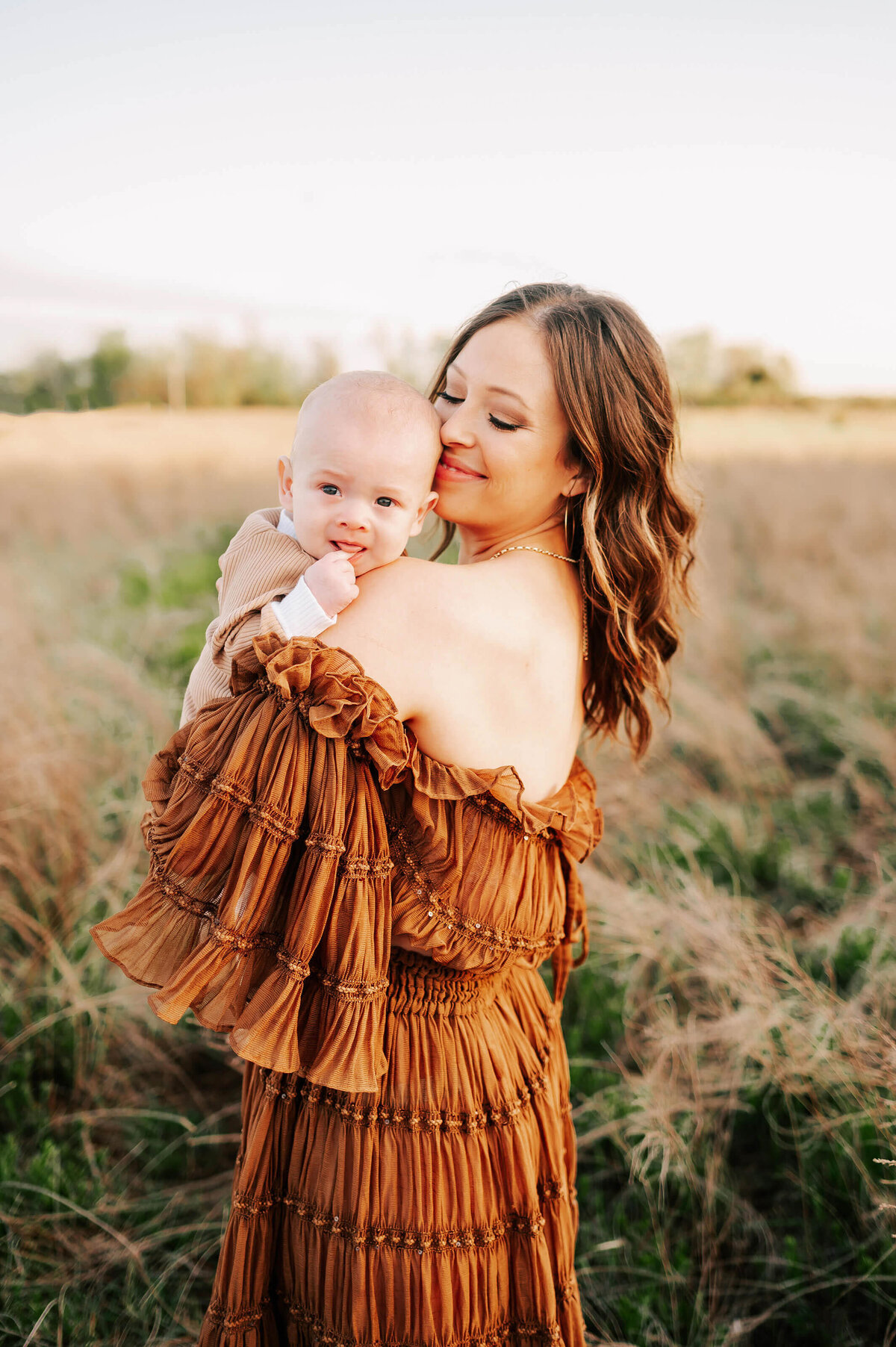 family pictures in Springfield MO of mom snuggling baby in a field