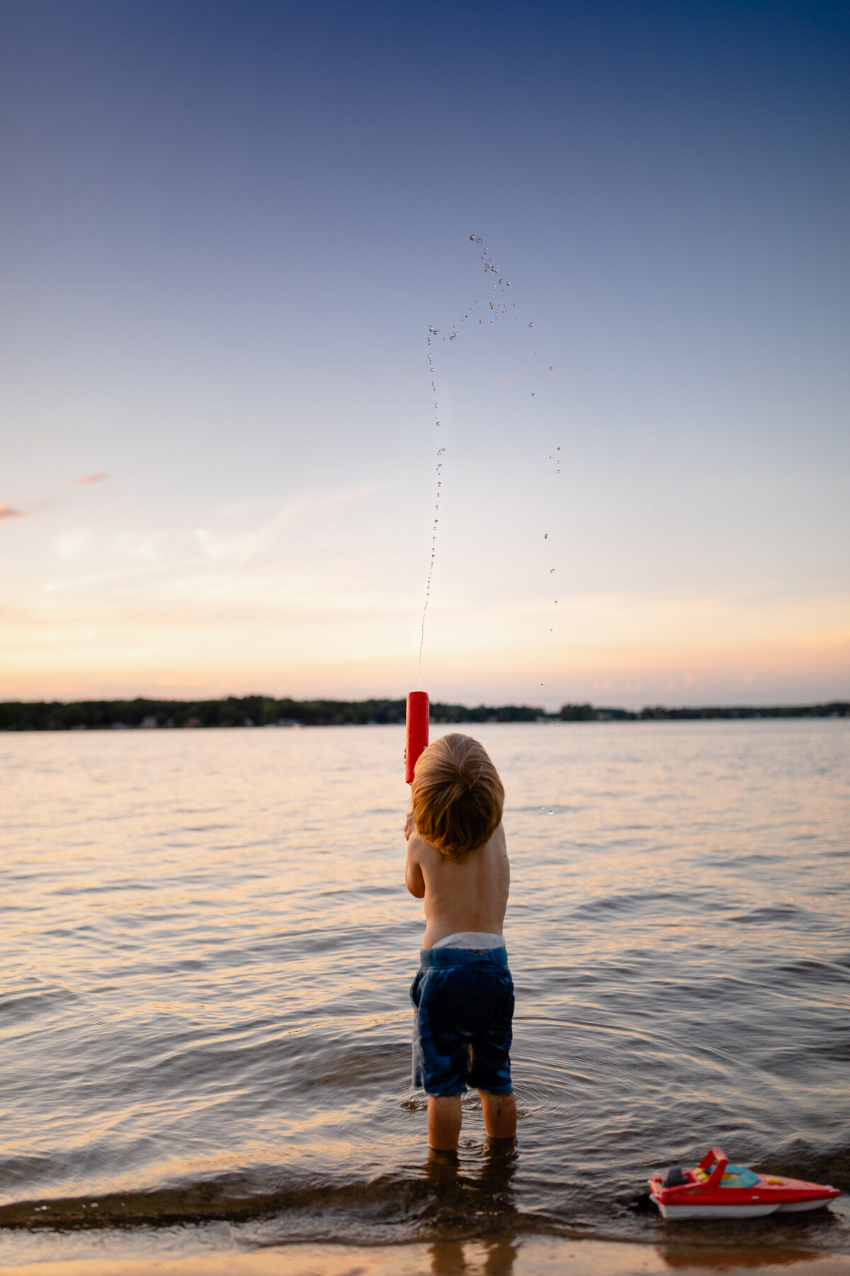 boy-spraying-water-dusk