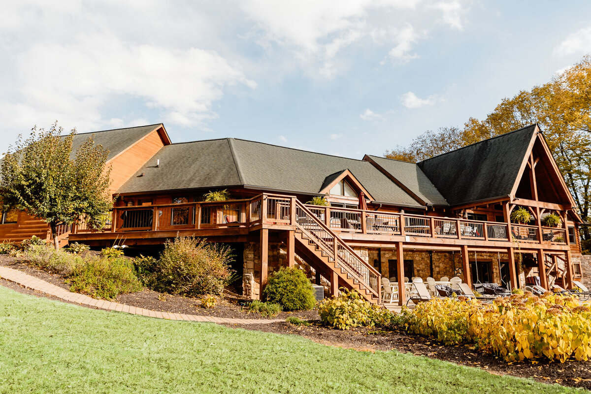 Rustic wooden lodge with expansive deck and greenery