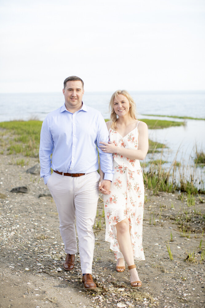 couple walking along the beach for engagement photos in Southport, CT