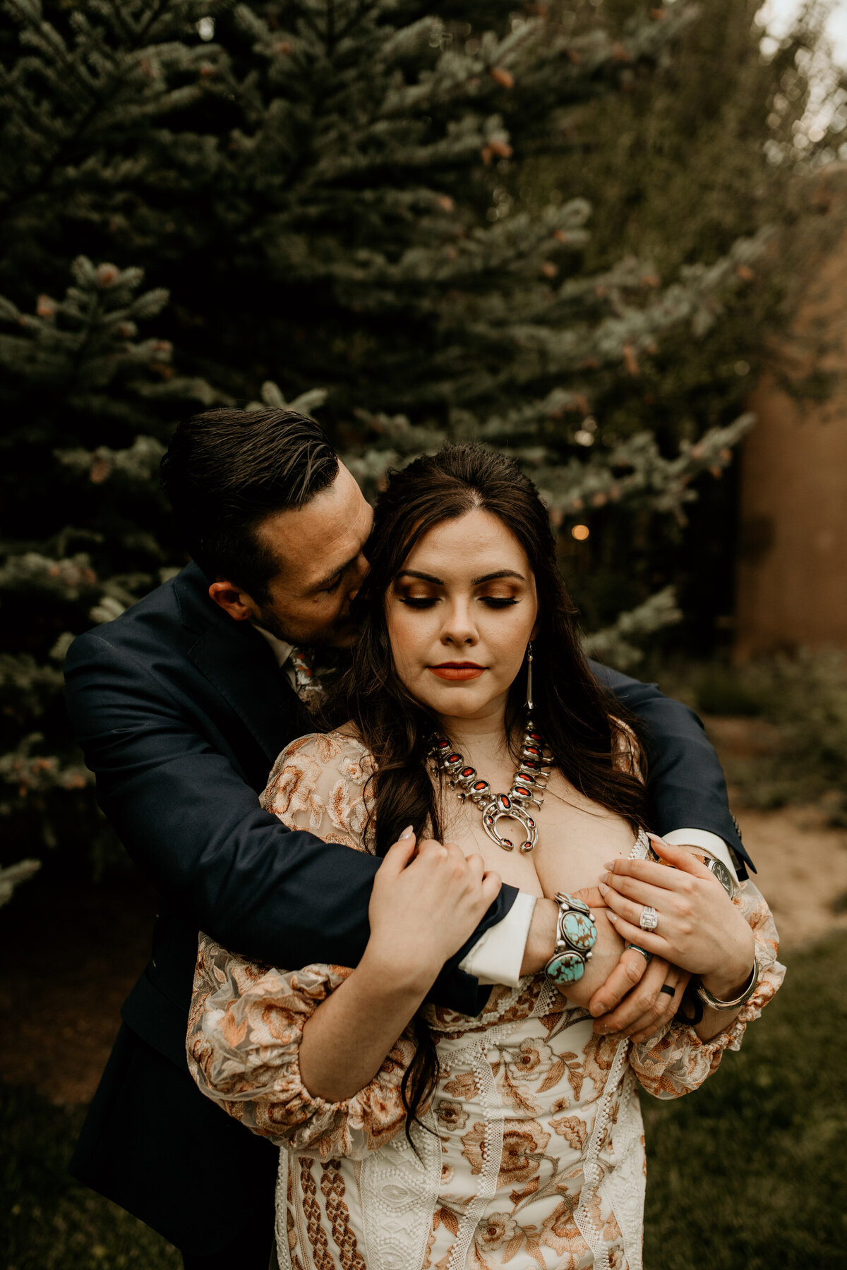 groom holding bride from behing at their southwest wedding in Taos New Mexico