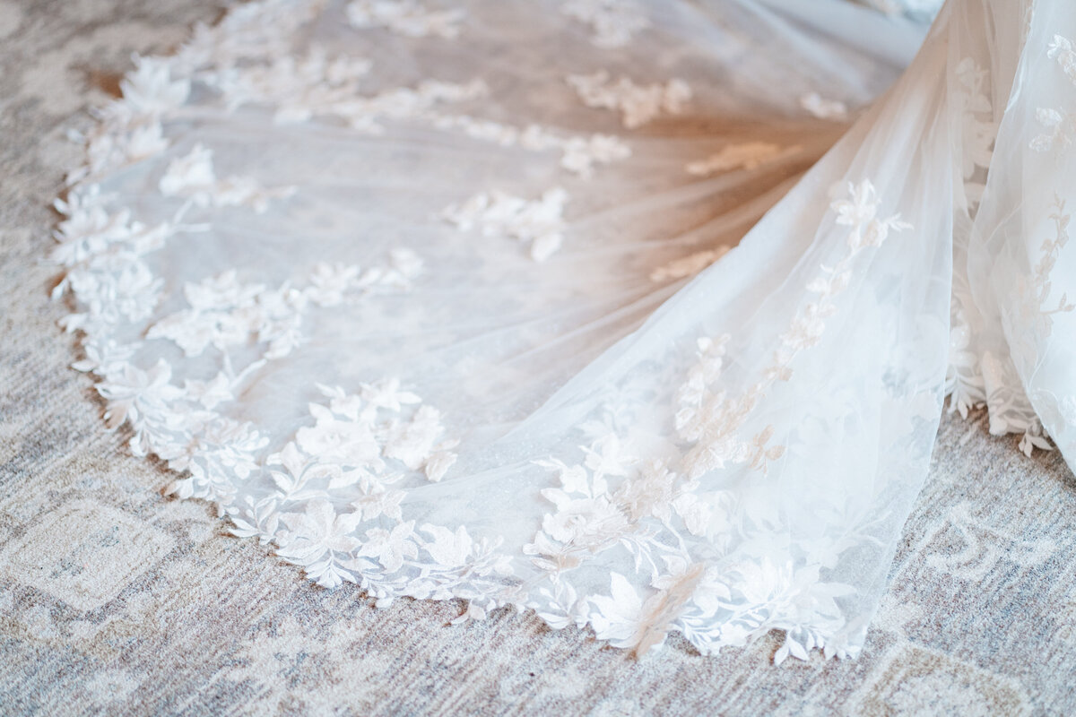 Bride putting on earrings in soft window light before her New England wedding