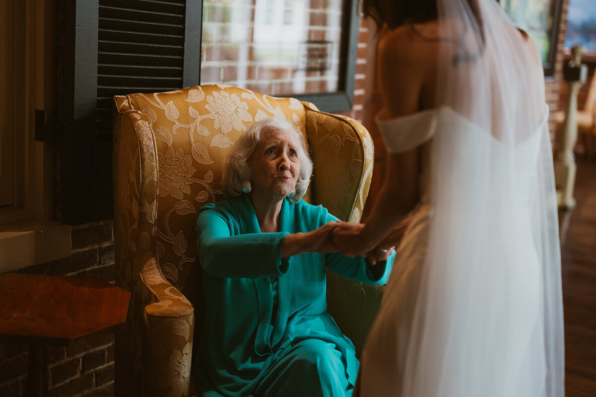grandma reaches out towards bride after seeing her