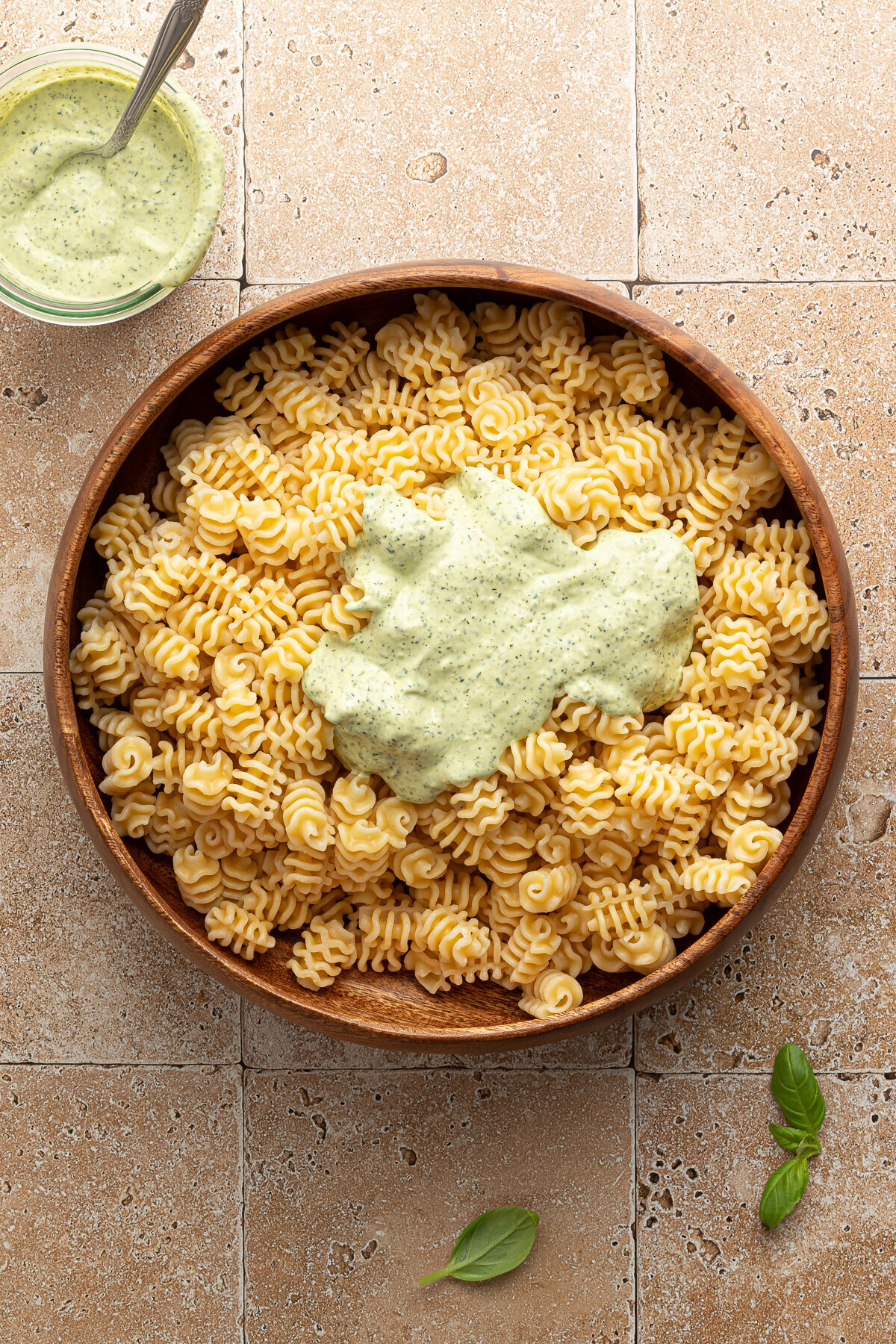 green sauce poured on top of a bowl of pasta