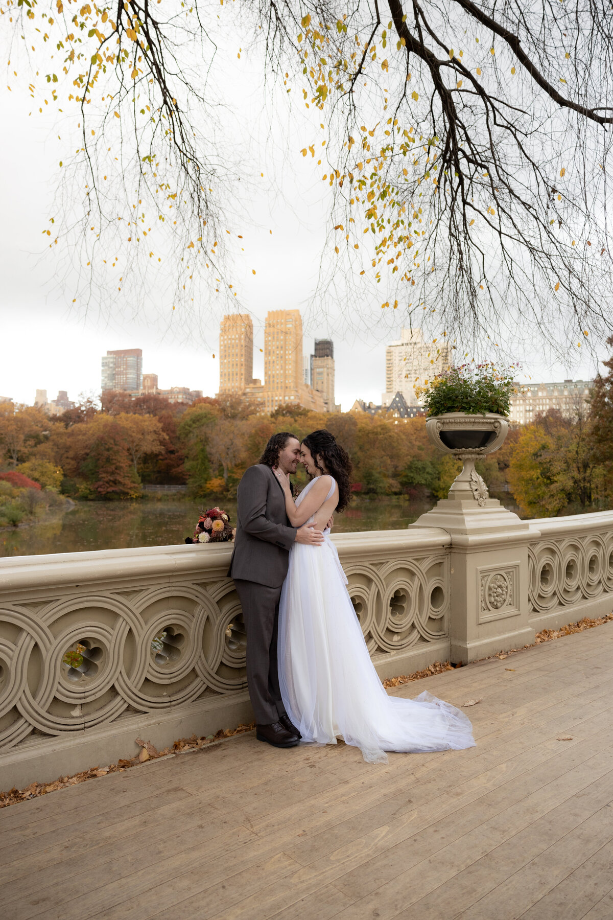 The couple sharing an intimate moment by the water’s edge surrounded by fall foliage.