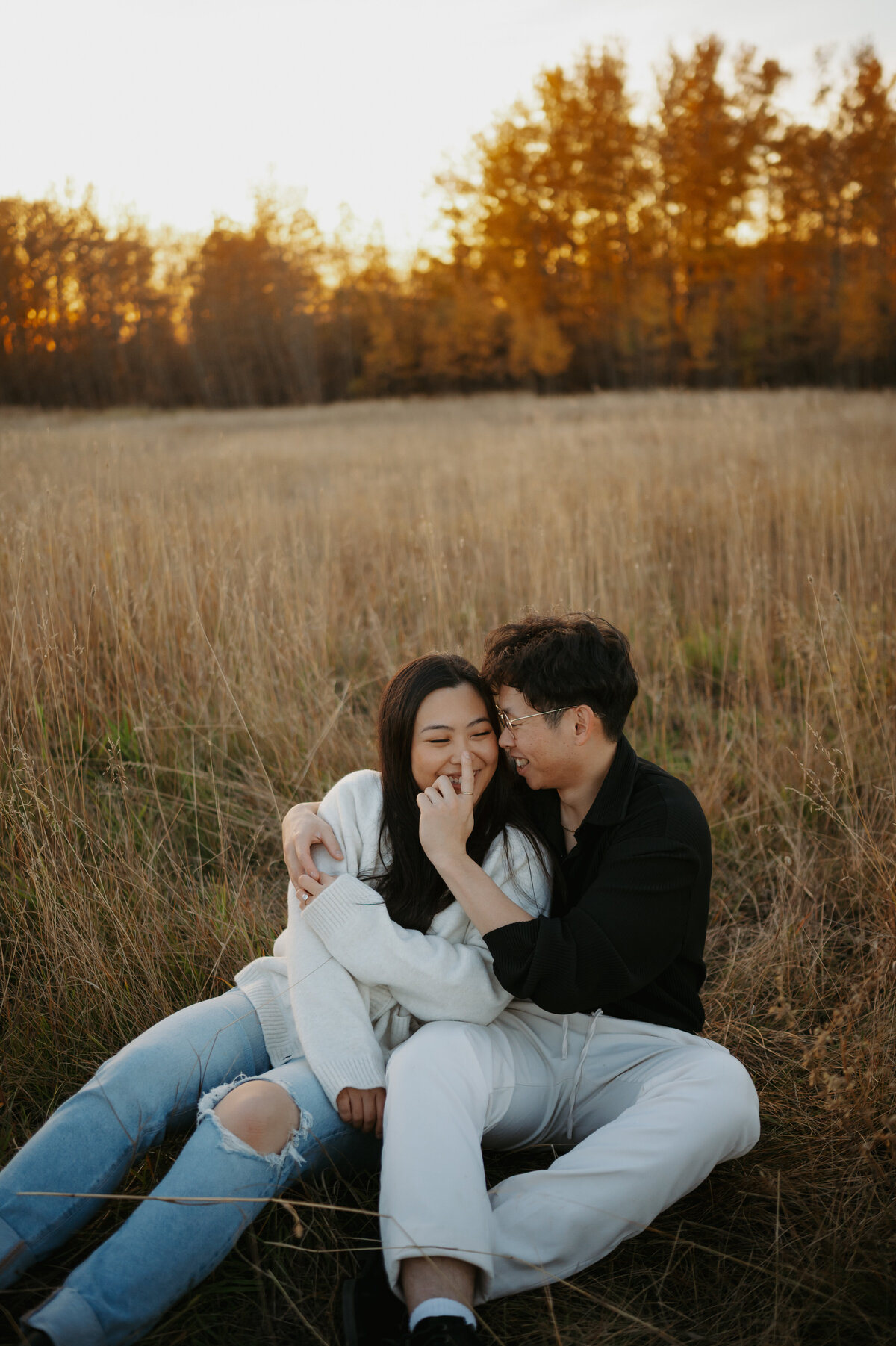 Edmonton outdoor photograph taken in fall of couple sitting in farmers field