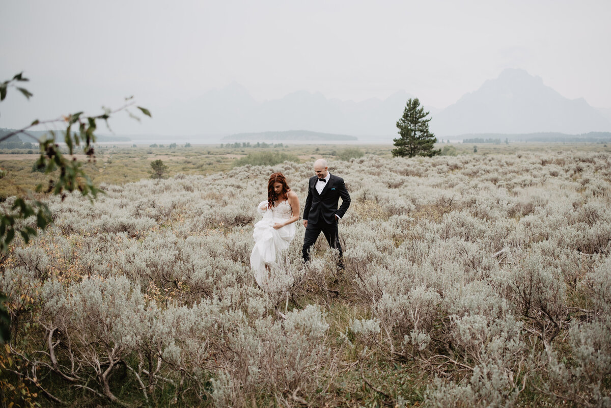 Jackson Hole Photographers capture bride and groom walking through sagebrush