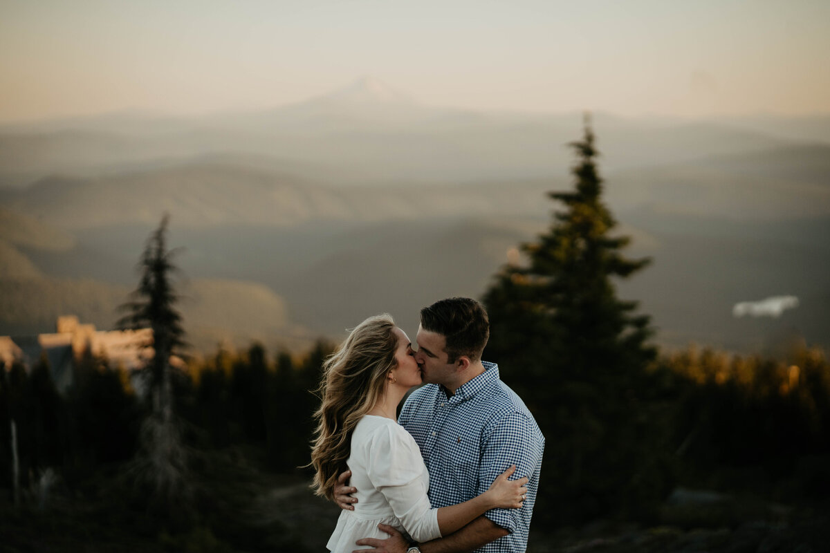 Couple kissing with views of the mountains behind them at Mt. Hood