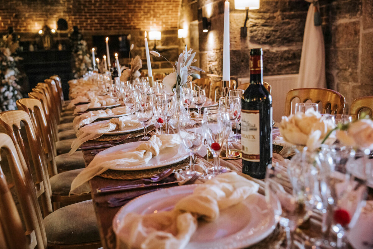 A table set for a formal dinner with a bottle of wine