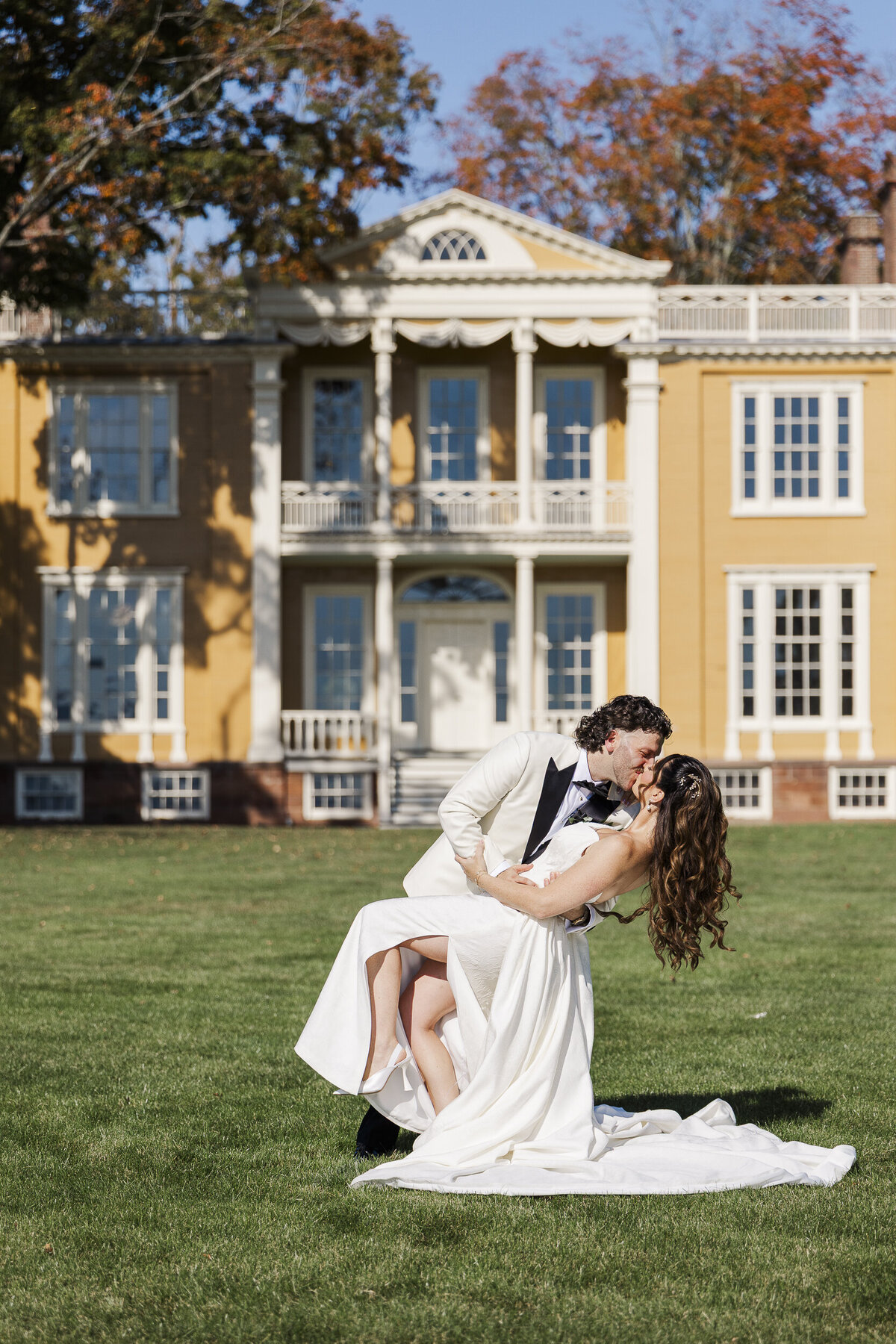 Kaitlin and Jacob sharing a dip kiss on the lawn at Boscobel on their wedding day