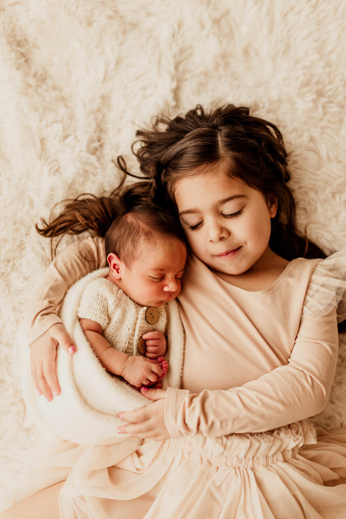 Brother and sister close their eyes and pretend to sleep.
