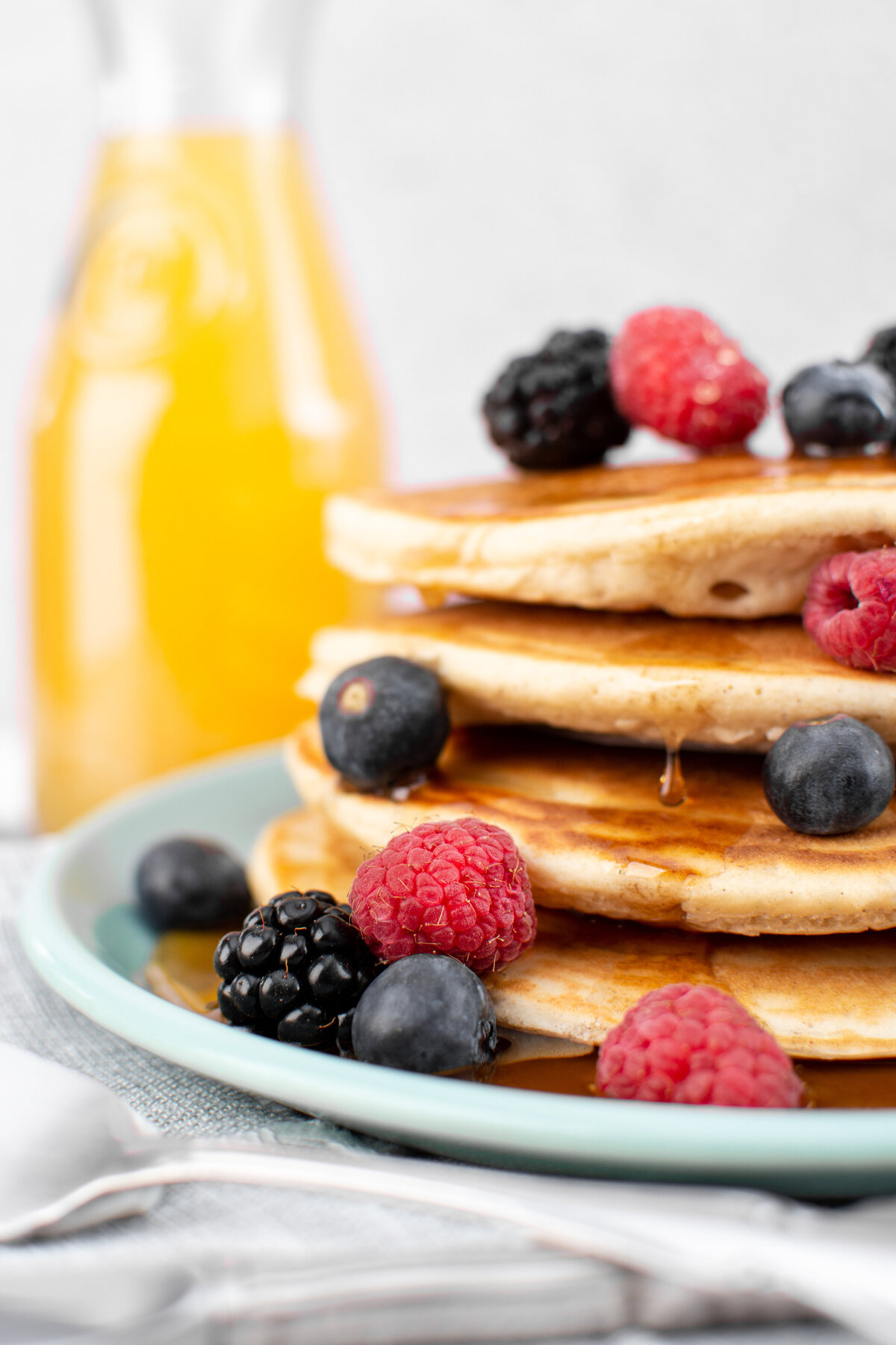 bisquick pancakes with mixed berries and orange juice.