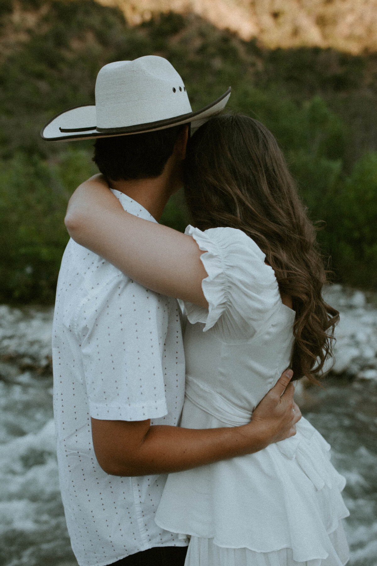 couple embracing looking towards the river