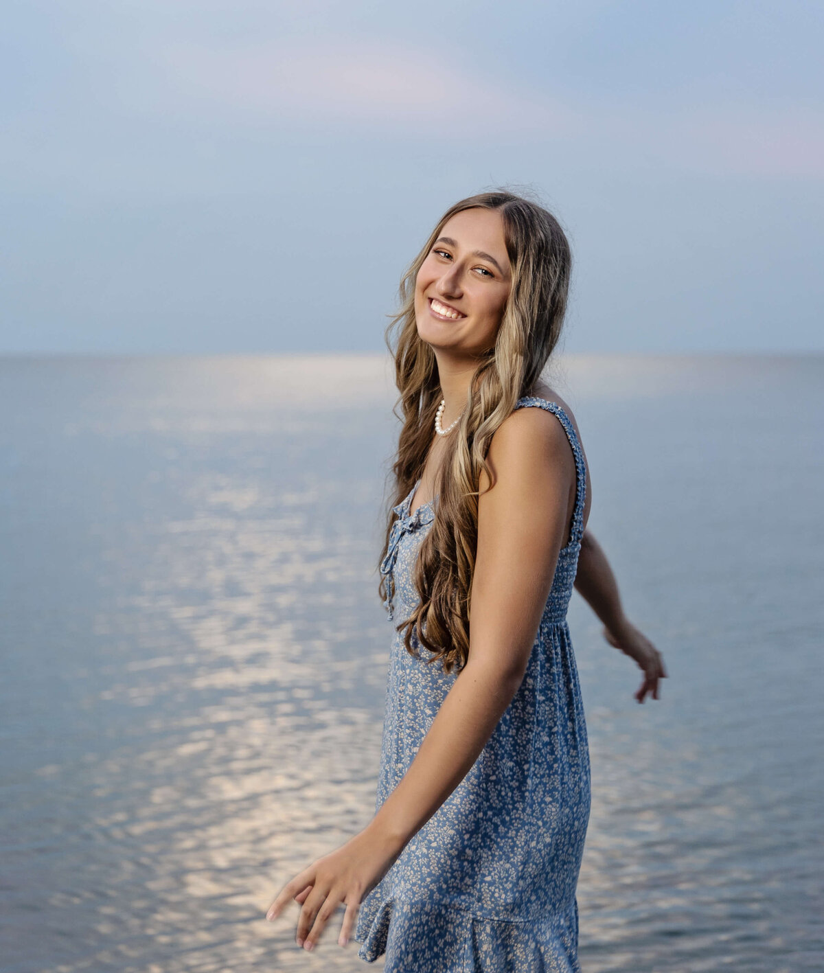 Senior photo of a girl twirling  around in the water at the Peninsula in Erie Pa