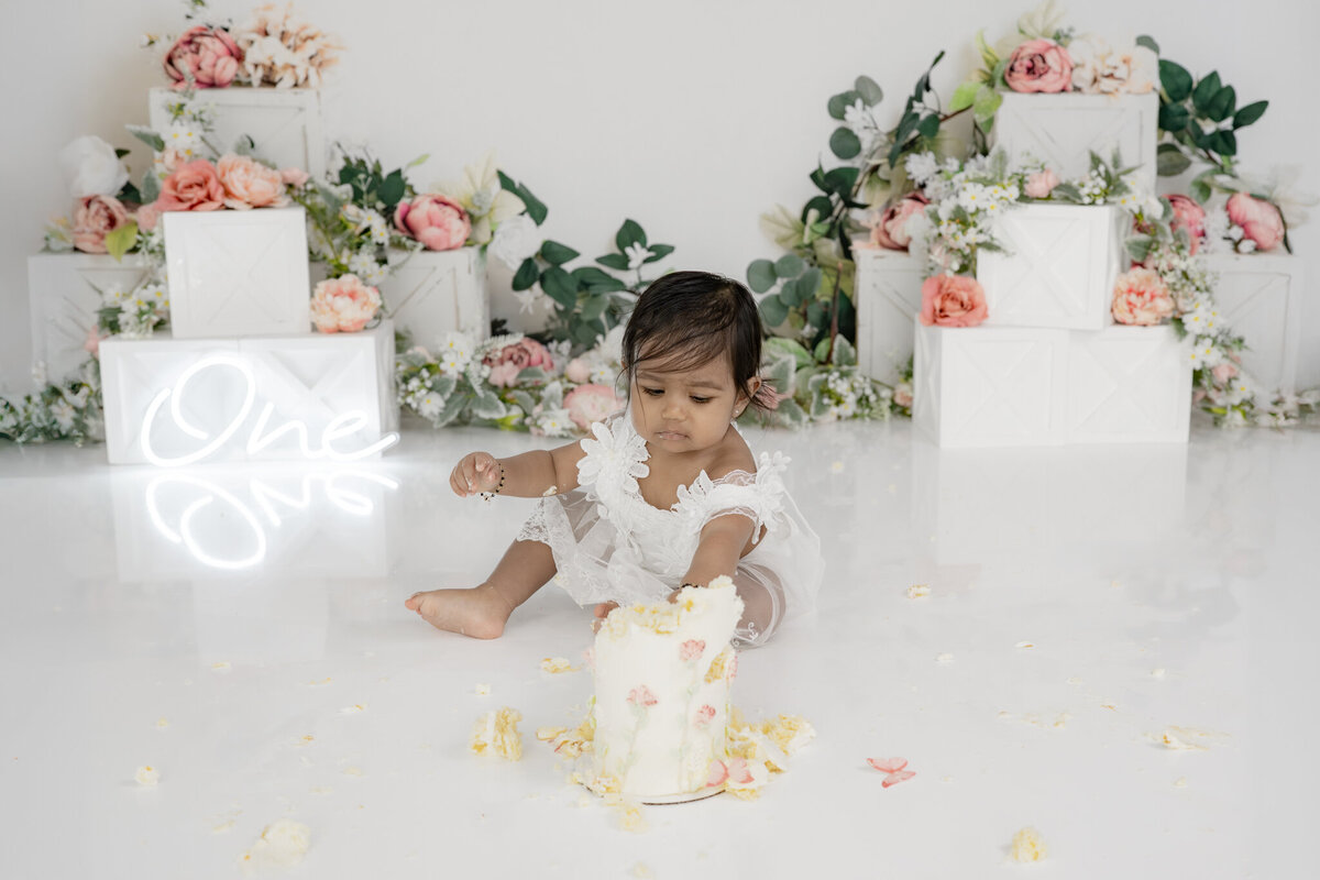 Girl eating cake during floral themed cake smash session— captured by Alliston and Barrie cake smash photographer.