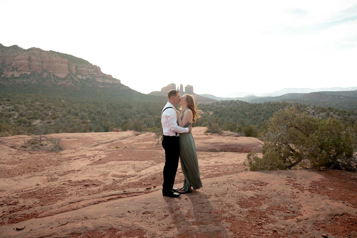 Couple standing against red rock backdrop during Sedona engagement session