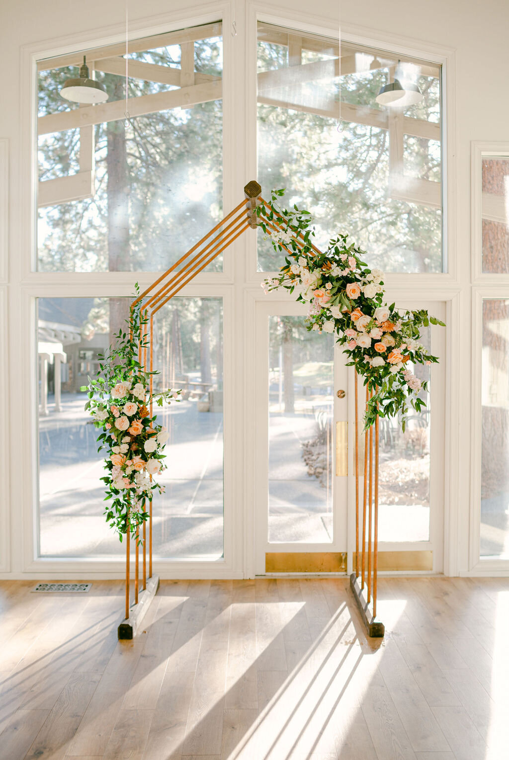 Pale peach and white roses and greenery on copper geo arch at White Aspen Creative all inclusive weddings in Bend Oregon
