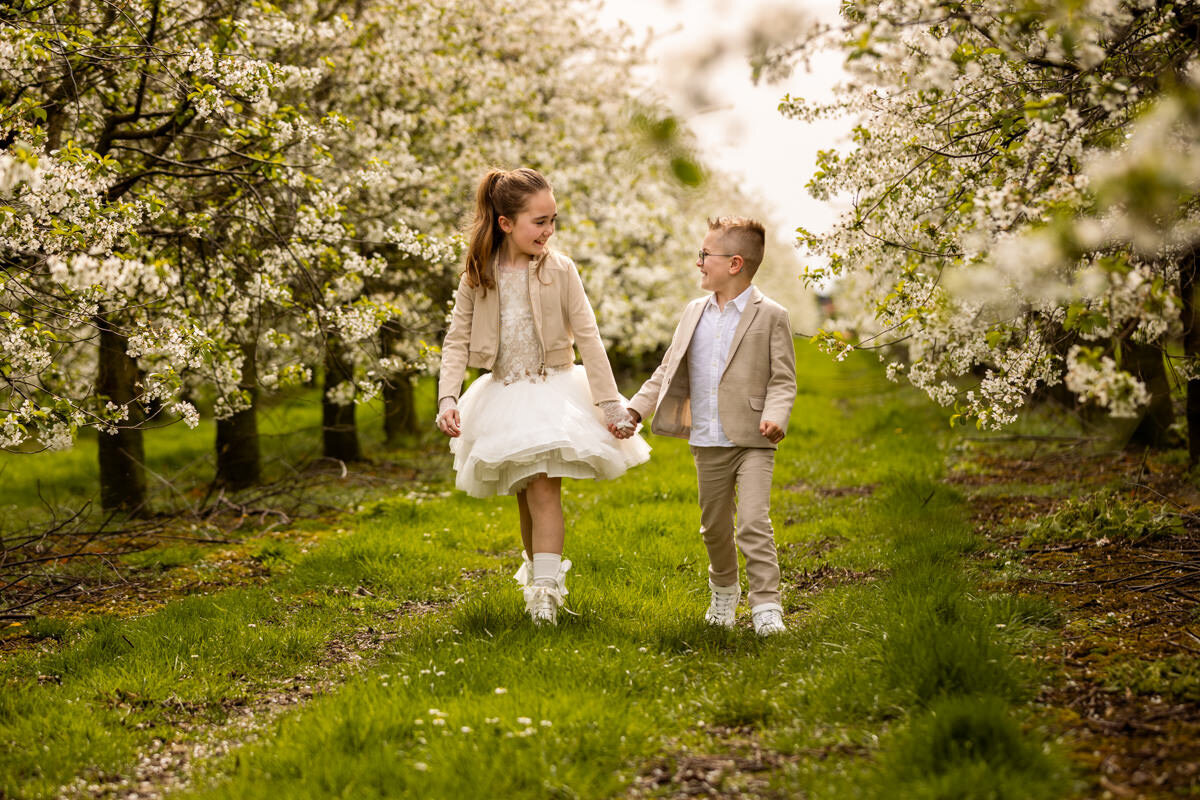 communiefoto meisje met broer bij bloesembomen