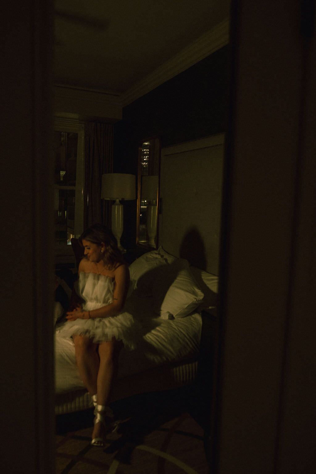 A person in a wedding dress sitting on a bed.