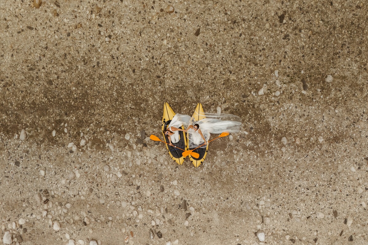 Aerial view of brides in yellow packraft in Soča Valley river elopement