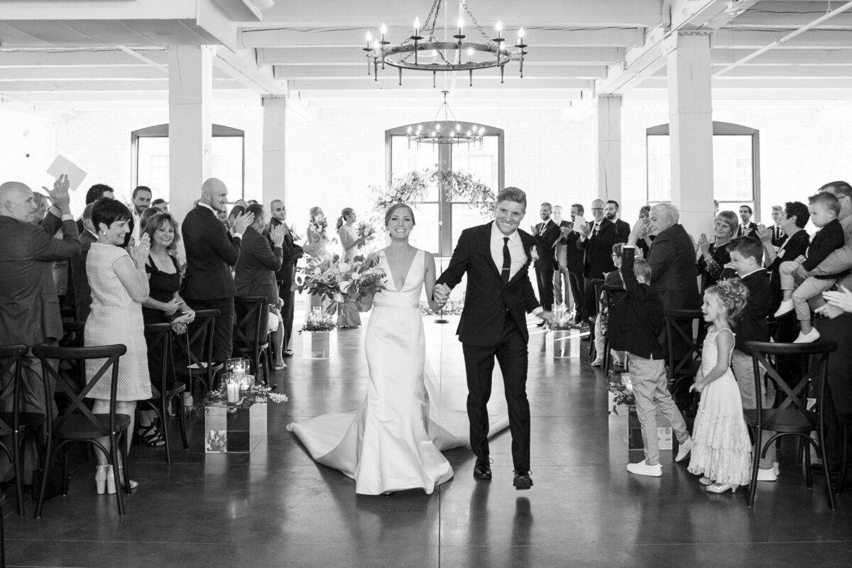 Just married couple walk down the aisle after exchanging a kiss in Columbus Ohio