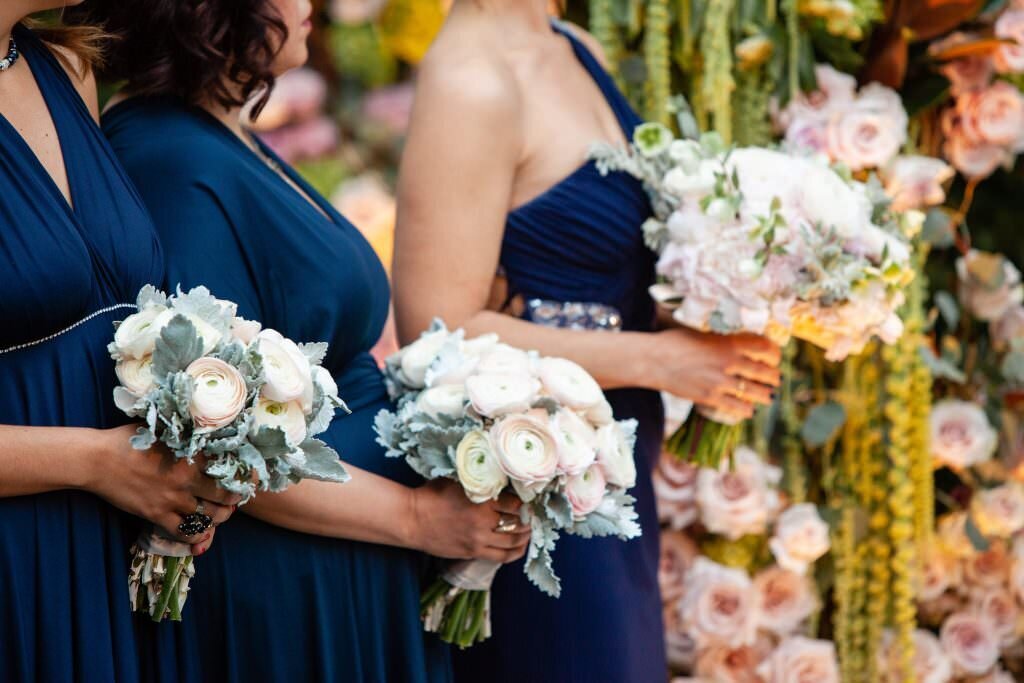 A line of bridesmaids holding bouquets of flowers