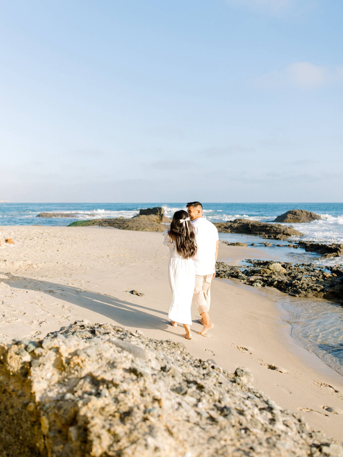 couple walking towards the ocean documentary engagement photo