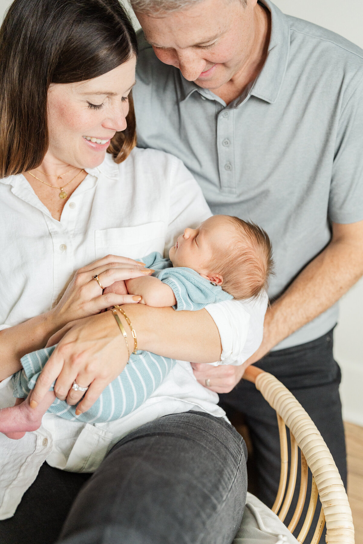 A mother and father gaze lovingly at their newborn child, sharing a moment of pure joy