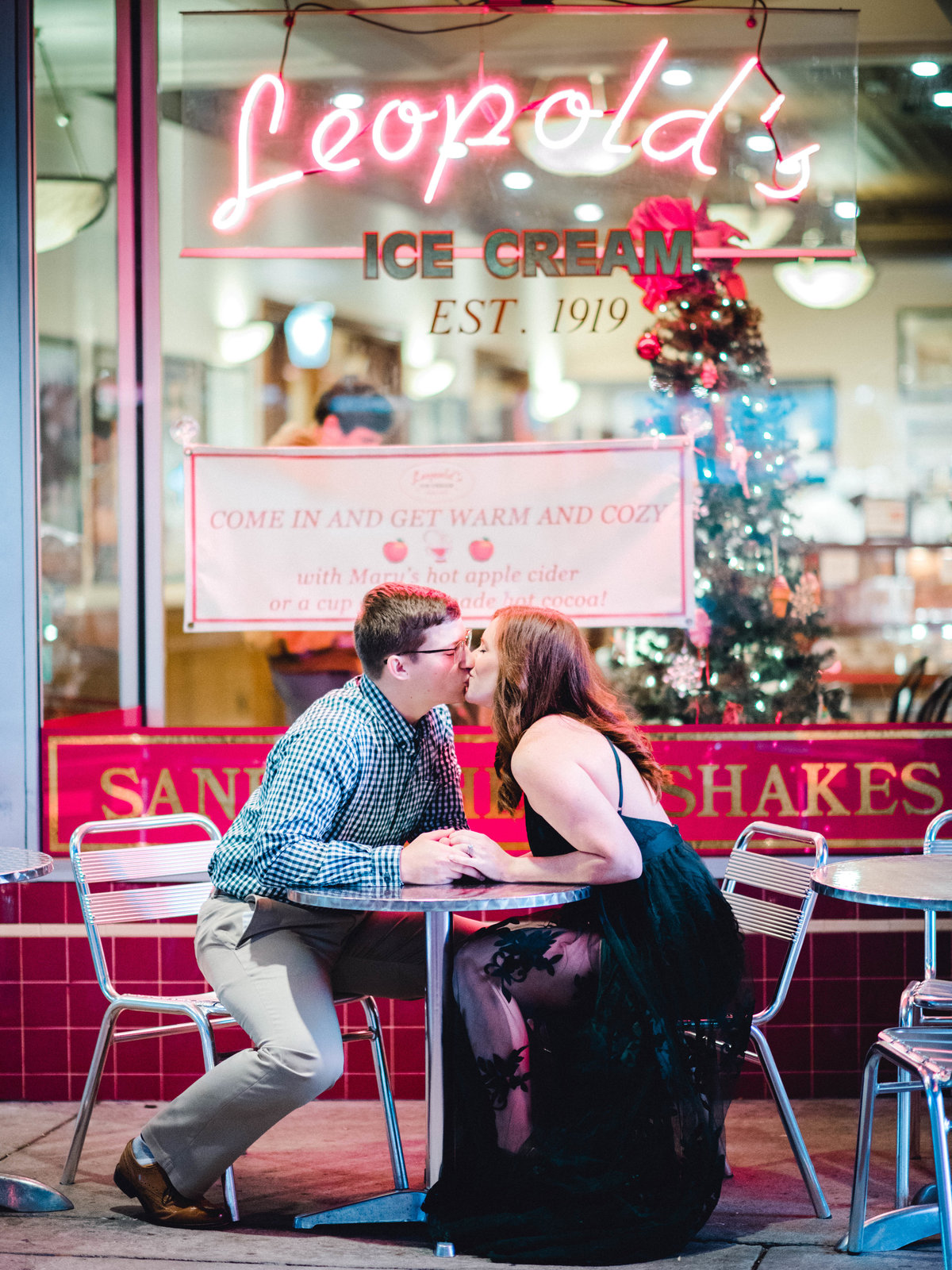 Couple sitting outside Leopold's Ice cream shop on Broughton Street in Savannah kissing